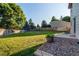 Expansive backyard with lush green grass, mature trees, and a privacy fence at 8538 W Glasgow Pl, Littleton, CO 80128