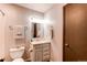 Neat bathroom with a vanity, toilet, mirror, and practical towel racks, all in neutral tones at 8538 W Glasgow Pl, Littleton, CO 80128