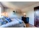 Calm bedroom with wood-look floors, complemented by wall art and warm lighting at 8538 W Glasgow Pl, Littleton, CO 80128