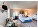 Bright bedroom boasts wood floors, a sitting area and a large bed with plush pillows and stylish decorations at 8538 W Glasgow Pl, Littleton, CO 80128