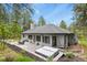 Charming home backyard featuring a patio with table, hot tub, lush green trees, and space for entertaining at 929 Tenderfoot Dr, Larkspur, CO 80118