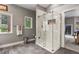 Bright bathroom featuring a modern glass shower and gray tile floors and walls at 929 Tenderfoot Dr, Larkspur, CO 80118