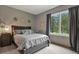 Bedroom with gray walls and a large window with views of the surrounding forest at 929 Tenderfoot Dr, Larkspur, CO 80118