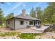 Back exterior of the home with a patio, hot tub, and views of the surrounding forest at 929 Tenderfoot Dr, Larkspur, CO 80118