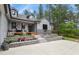 Charming gray home featuring a quaint front porch, gray stone, and lush landscaping at 929 Tenderfoot Dr, Larkspur, CO 80118