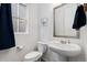 This is a bathroom with a toilet, pedestal sink, mirror, and white walls at 18060 E 106Th Pl, Commerce City, CO 80022