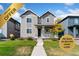 Charming two-story home with gray siding, front porch, and manicured lawn at 18060 E 106Th Pl, Commerce City, CO 80022