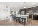 Open concept kitchen featuring a large center island, seating, and modern stainless steel appliances at 18060 E 106Th Pl, Commerce City, CO 80022
