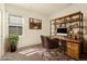 Charming office space with custom shelving, a leather desk chair, and natural light from a window at 18060 E 106Th Pl, Commerce City, CO 80022