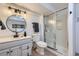 Modern bathroom with a round mirror, new light fixture, and step-in shower at 10425 Red Mountain West, Littleton, CO 80127