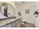 Modern bathroom with a granite countertop vanity, round mirror, and walk-in shower at 10425 Red Mountain West, Littleton, CO 80127