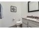 Half bath with decorative mirror and vanity with granite countertop at 10425 Red Mountain West, Littleton, CO 80127