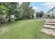 Lush green backyard with mature trees, a wooden fence, and plenty of space for outdoor activities at 7123 S Hudson Cir, Centennial, CO 80122