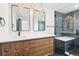 Modern bathroom with stylish vanity, double mirrors, a glass shower, and sleek fixtures at 7123 S Hudson Cir, Centennial, CO 80122
