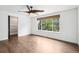 Well-lit bedroom with dark wood floors, white walls, and a large window overlooking green trees at 7123 S Hudson Cir, Centennial, CO 80122