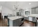Modern kitchen features gray cabinets, stainless steel appliances, marble counters, and a unique, contemporary light fixture at 7123 S Hudson Cir, Centennial, CO 80122