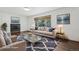 Bright, staged living room boasts a cozy fireplace, large window, and stylish, contemporary furnishings at 7123 S Hudson Cir, Centennial, CO 80122