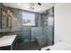 Close-up of a modern glass shower featuring sleek tile, a rain showerhead, and bench seating at 7123 S Hudson Cir, Centennial, CO 80122