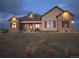 House exterior at dusk, showcasing stone accents and landscaping at 38911 E Wesley Ave, Bennett, CO 80102