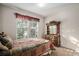 Bedroom with natural light, carpet floors, window with blinds, bed and wood dresser at 6626 S Reed Way # A, Littleton, CO 80123