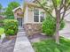 Inviting front entrance with stone accents, lush greenery, and a well-maintained walkway at 6626 S Reed Way # A, Littleton, CO 80123