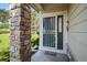 Close up of front porch featuring a gray security door and stone pillar at 6626 S Reed Way # A, Littleton, CO 80123
