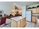 Open concept kitchen and living area with a center island and tile flooring at 6626 S Reed Way # A, Littleton, CO 80123