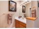 Bright bathroom featuring double sinks, vanity with bright lighting, tile countertop, and a decorative painting at 73 Falcon Hills Dr, Highlands Ranch, CO 80126