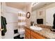 Well-lit bathroom with a granite vanity, a framed mirror, and a shower-tub with a curtain at 73 Falcon Hills Dr, Highlands Ranch, CO 80126