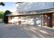 Three-car garage with brick accents and a concrete driveway at 73 Falcon Hills Dr, Highlands Ranch, CO 80126