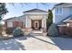 Inviting home entrance with covered portico and brick facade at 73 Falcon Hills Dr, Highlands Ranch, CO 80126