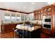 Elegant kitchen with dark wood cabinets, large island and granite countertops at 73 Falcon Hills Dr, Highlands Ranch, CO 80126