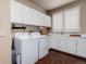 Bright laundry room featuring white cabinets, modern washer and dryer, and a convenient folding area with sink at 73 Falcon Hills Dr, Highlands Ranch, CO 80126