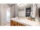 Well-lit bathroom with a vanity sink, with a shower and an open door to the hallway at 5436 S Versailles Way, Aurora, CO 80015