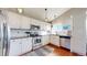Well-lit kitchen featuring white cabinets, stainless steel appliances, granite counters, and hardwood floors at 5436 S Versailles Way, Aurora, CO 80015