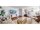 Comfortable living room with hardwood floors, white walls, television and a view of the staircase and kitchen at 5436 S Versailles Way, Aurora, CO 80015