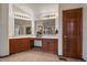 Bright bathroom featuring a double vanity, wooden cabinets, and large mirrors at 7914 S Clayton Cir, Centennial, CO 80122