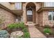 Charming brick home with a grand arched entrance, stone walkway, and well-maintained landscaping at 7914 S Clayton Cir, Centennial, CO 80122