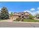 Inviting brick two-story home with manicured lawn, mature trees, and three-car garage at 7914 S Clayton Cir, Centennial, CO 80122