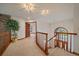 Well-lit hallway with carpet flooring, wooden railings, and a large plant at 7914 S Clayton Cir, Centennial, CO 80122