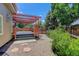 Backyard deck features a wooden pergola, stone paver border and a rock garden at 1446 Braewood Ave, Highlands Ranch, CO 80129