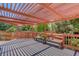 Deck with an overhead pergola, bench seating, and flower pots at 1446 Braewood Ave, Highlands Ranch, CO 80129