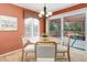 Sunny dining area showcasing a round table, comfortable chairs, a sliding door, and an adjacent outdoor deck at 1446 Braewood Ave, Highlands Ranch, CO 80129