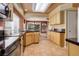 Well-lit kitchen featuring wood cabinets, a peninsula counter, and seamless connection to the dining area at 1446 Braewood Ave, Highlands Ranch, CO 80129