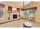 Comfortable living room with a fireplace and views of the surrounding neighborhood through expansive windows at 1446 Braewood Ave, Highlands Ranch, CO 80129