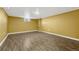 This basement features wood-look laminate flooring, yellow walls, and a small window at 1051 Lima St, Aurora, CO 80010