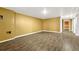 This basement features wood-look laminate flooring, yellow walls, and a baseboard at 1051 Lima St, Aurora, CO 80010