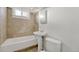 This bathroom features a shower-tub combo, pedestal sink, toilet, and tiled walls and flooring at 1051 Lima St, Aurora, CO 80010