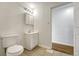 This bathroom features a toilet, sink with vanity, light fixture, and tiled flooring at 1051 Lima St, Aurora, CO 80010