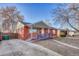 Charming single-story brick home with a ramp and front yard featuring mature trees and a cozy front porch at 1051 Lima St, Aurora, CO 80010